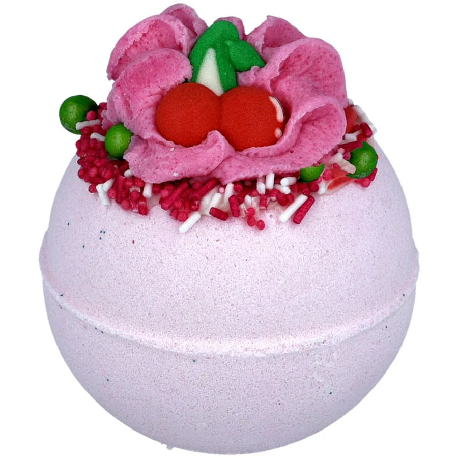Decorative bath bomb with pink flower and red berries on a white background